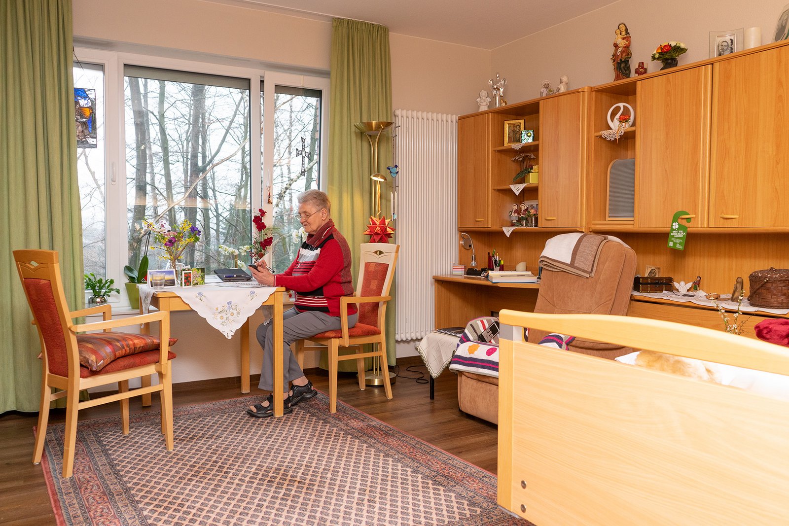 Eine Frau sitzt in ihrem Zimmer an einem Tisch